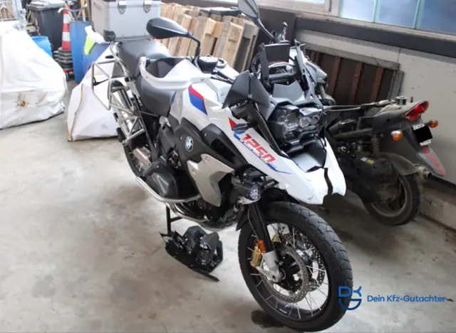 Weiße BMW R 1250 GS mit Unfallschaden, abgestellt in einer Garage